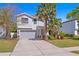 Charming two-story home with a well-manicured lawn, a two-car garage, and beautiful palm trees at 3615 W Kensington Ave, Tampa, FL 33629