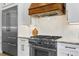Close up of a gourmet kitchen featuring stainless steel appliances and a custom wood range hood at 3615 W Kensington Ave, Tampa, FL 33629