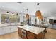 Modern kitchen featuring a central island with seating, stylish pendant lights, and stainless steel appliances at 3615 W Kensington Ave, Tampa, FL 33629