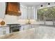Close up of a gourmet kitchen featuring stainless steel appliances and a custom wood range hood at 3615 W Kensington Ave, Tampa, FL 33629