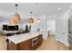 Bright kitchen featuring a central island with seating, stylish pendant lights, and stainless steel appliances at 3615 W Kensington Ave, Tampa, FL 33629