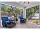 Cozy screened patio with wicker furniture, lush greenery, and a view of the pool at 3615 W Kensington Ave, Tampa, FL 33629