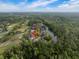 Expansive aerial view showcases the community with a golf course, a lake, and the location of the property with a red arrow at 3633 Cordgrass Dr, Valrico, FL 33596