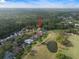 An aerial view showcases a home surrounded by mature trees and a golf course nearby at 3633 Cordgrass Dr, Valrico, FL 33596