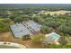 Aerial view of community amenities featuring tennis courts and a swimming pool surrounded by lush greenery and mature trees at 3633 Cordgrass Dr, Valrico, FL 33596