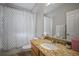 This bathroom features granite counters, wood cabinets and shower with patterned curtain at 3633 Cordgrass Dr, Valrico, FL 33596