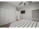 This bedroom features wood-look flooring, a ceiling fan, and a closet with bi-fold doors at 3633 Cordgrass Dr, Valrico, FL 33596