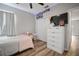 This bedroom features wood flooring, a ceiling fan, closet, and comfortable bed at 3633 Cordgrass Dr, Valrico, FL 33596