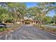 Beautiful clubhouse entrance framed by lush landscaping and mature trees at 3633 Cordgrass Dr, Valrico, FL 33596