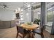 Dining area with modern light fixture, large windows, hardwood flooring and view of living space with fireplace at 3633 Cordgrass Dr, Valrico, FL 33596
