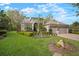 Inviting home exterior with well-maintained lawn, mature trees, and a paver driveway at 3633 Cordgrass Dr, Valrico, FL 33596