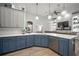 Charming kitchen with quartz countertops, blue cabinets, hardwood floors, and stainless steel appliances at 3633 Cordgrass Dr, Valrico, FL 33596