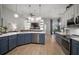 Open kitchen with blue cabinets, stainless steel dishwasher, and views into the living area at 3633 Cordgrass Dr, Valrico, FL 33596