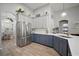 Elegant kitchen featuring blue and white cabinetry, stainless steel refrigerator, and wood floors at 3633 Cordgrass Dr, Valrico, FL 33596