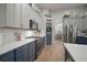 Updated kitchen with stainless steel appliances, white countertop, blue and gray cabinets and hardwood flooring at 3633 Cordgrass Dr, Valrico, FL 33596