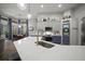 Modern kitchen features a large island with a gold faucet, stainless appliances, and a pantry door at 3633 Cordgrass Dr, Valrico, FL 33596