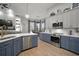 Open kitchen boasts stainless appliances, blue lower cabinets, white uppers, and a view to the living space at 3633 Cordgrass Dr, Valrico, FL 33596