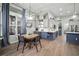Eat-in kitchen includes dining table, blue lower cabinets, white countertops and stainless steel refrigerator at 3633 Cordgrass Dr, Valrico, FL 33596