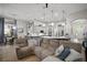 Open-concept living room with open kitchen and dining area features a comfortable sectional couch and natural lighting at 3633 Cordgrass Dr, Valrico, FL 33596