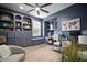 Stylish home office with blue built-in bookshelves, cabinets, desk, and ample natural light at 3633 Cordgrass Dr, Valrico, FL 33596