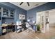 Well-lit home office with blue built-ins, dual desks, and modern office chairs at 3633 Cordgrass Dr, Valrico, FL 33596