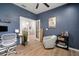 Comfortable office space featuring wood-look floors, a modern desk, and a gray armchair at 3633 Cordgrass Dr, Valrico, FL 33596