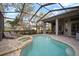 The screened-in lanai features a pool, spa, lounge seating, and overlooks the golf course at 3633 Cordgrass Dr, Valrico, FL 33596