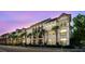 Charming multi-story building with stucco exterior, arches, palm trees and balconies against a beautiful sunset backdrop at 402 S Armenia Ave # 137, Tampa, FL 33609