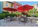 Outdoor patio area with multiple seating arrangements and red umbrellas at 402 S Armenia Ave # 137, Tampa, FL 33609