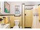 Classic yellow tiled bathroom featuring shower, decorative wall art, and bright lighting at 4101 W El Prado Blvd, Tampa, FL 33629