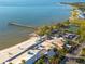Expansive aerial view of the beach, showcasing the pier, clear waters, and tropical palm trees at 418 Bahia Beach Blvd, Ruskin, FL 33570