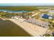 Wide aerial shot captures sandy beach, parking, and resort area by the water, plus surrounding landscape at 418 Bahia Beach Blvd, Ruskin, FL 33570