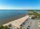 Picturesque aerial view of the beach with calm waters, parking area, and the beach pier at 418 Bahia Beach Blvd, Ruskin, FL 33570