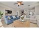 Comfortable living area featuring stylish sofas, a ceiling fan, and modern decor with sunlight streaming through the windows at 418 Bahia Beach Blvd, Ruskin, FL 33570