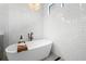 Freestanding tub with sleek faucet and tray, set against a backdrop of white tiled walls and modern chandelier at 4806 W San Rafael St, Tampa, FL 33629