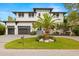 Beautiful two-story modern home featuring a well-manicured lawn, a palm tree, and a two-car garage at 4806 W San Rafael St, Tampa, FL 33629