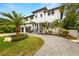 Beautiful two-story modern home featuring a well-manicured lawn, a palm tree, and a two-car garage at 4806 W San Rafael St, Tampa, FL 33629