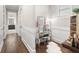 Elegant hallway with white wainscoting leading to a vanity and a bathroom, features hardwood floors at 4806 W San Rafael St, Tampa, FL 33629