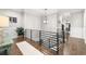 Hallway featuring hardwood floors, modern railing, pendant light and access to the laundry room at 4806 W San Rafael St, Tampa, FL 33629