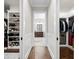 Hallway view into bathroom and walk-in closets with hardwood floors and white trim at 4806 W San Rafael St, Tampa, FL 33629