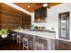 Well-equipped outdoor kitchen with a countertop bar, grill, sink, and wooden ceiling at 4806 W San Rafael St, Tampa, FL 33629