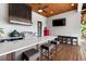 Well-equipped outdoor kitchen with a countertop bar, grill, sink, and wooden ceiling at 4806 W San Rafael St, Tampa, FL 33629
