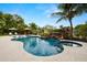 Resort-style pool with lush landscaping, a waterfall feature, integrated spa, and lounge chairs at 4806 W San Rafael St, Tampa, FL 33629