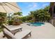 Backyard view of resort style pool with a lounging chairs, luscious landscaping and canal view at 4806 W San Rafael St, Tampa, FL 33629