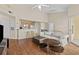 Open-concept living room with hardwood floors, ceiling fan, breakfast bar, and sliding door access at 5125 Palm Springs Blvd # 11306, Tampa, FL 33647