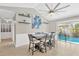Dining area with wainscoting, tile floors, slider to pool and modern ceiling fan at 6208 Imperial Ky, Tampa, FL 33615
