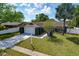 A single-story blue home with a manicured lawn, mature landscaping, and a paved driveway leading to an attached garage at 6208 Imperial Ky, Tampa, FL 33615