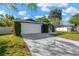 Single story blue home with a two-car garage, driveway, manicured lawn, and mature landscaping at 6208 Imperial Ky, Tampa, FL 33615