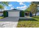 Charming single-story home featuring a two-car garage and well-manicured landscaping, painted in a serene blue hue at 6208 Imperial Ky, Tampa, FL 33615