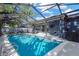 Enclosed pool with clear blue water featuring outdoor seating, and lush landscaping at 6208 Imperial Ky, Tampa, FL 33615